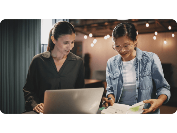 Two team members working together on a laptop.